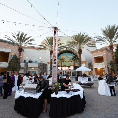 Event tables, catering, and bistro lights in courtyard