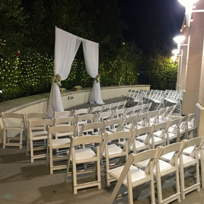 Outdoor wedding ceremony with white chairs