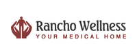 Logo with a maroon symbol resembling stylized hands or a geometric emblem to the left of the text 'Rancho Wellness' in dark lettering, followed by the tagline 'Your Medical Home' underneath.