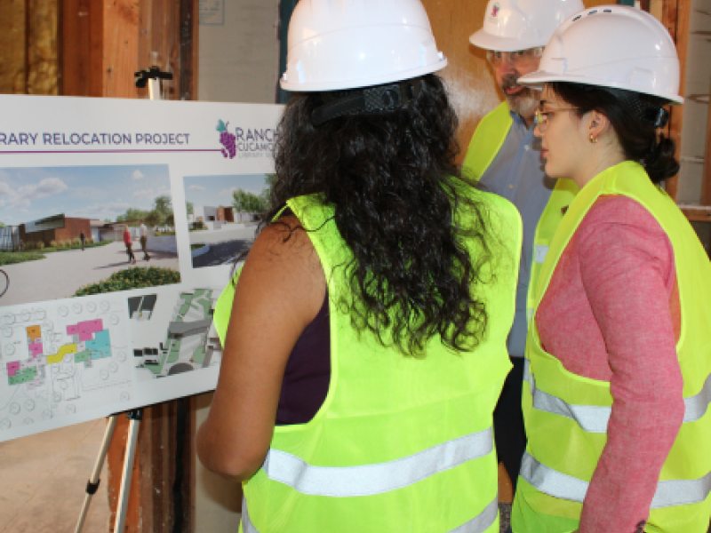 Westside Library Expansion Project Construction photo with board members looking at building rendering