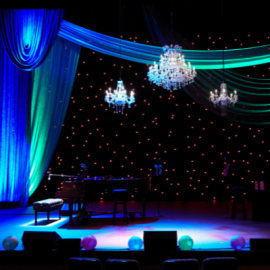 Elegant stage drapes with 3 chandeliers and grand piano