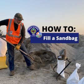 Volunteer filling up a sandbag