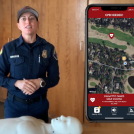 Firefighter standing in front of a manikin preparing to give a demonstration on how to perform CPR