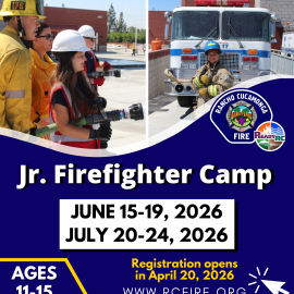 Jr. Firefighter Campers spraying the hose and standing in turnout gear in front of a fire engine