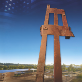Promotional graphic for 9/11 Remembrance Ceremony 25 anniversary. Image shows a tall rusted steel beam structure, positioned upright and prominently centered, resembling a remnant from the World Trade Center. The structure stands against a blue sky background with a faint American flag pattern in the upper portion. Below the structure is a landscaped outdoor area with buildings, trees, and parked vehicles, suggesting a memorial or civic space.